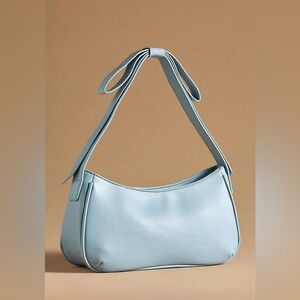 Powder blue shoulder bag with bow detail on strap. Excellent condition with tags